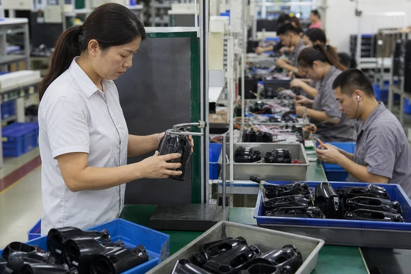 Inspector checking semi-finished units during active factory production