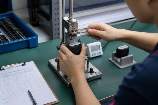 Factory technician performing a controlled functional test on a product sample